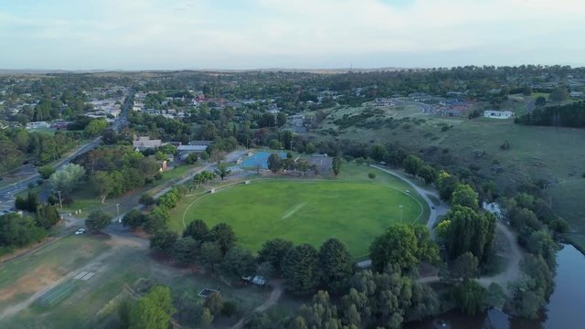 Forward flight towards sports oval in rural town at sunset in Australia