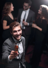 stylish young man raising a glass of wine