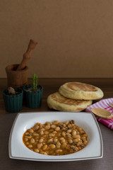 Turkish Kuru Fasulye with Bazlama bread in a white plate with decorated background. Haricot Bean is Turkish Traditional Food. 