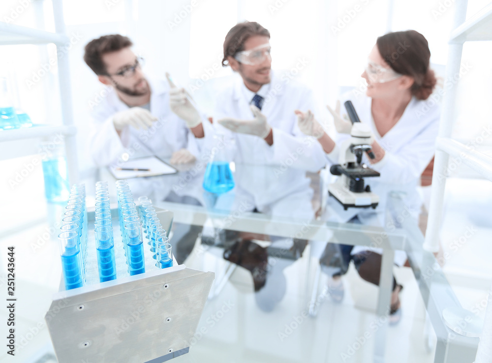 Wall mural background image of scientists studying blue liquid in a flask