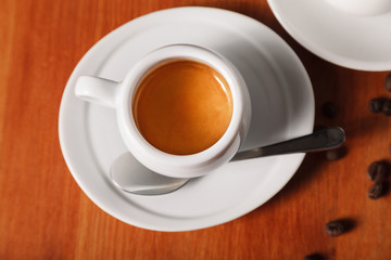White coffee Cup with delicious foam, close-up top view on wooden background. Concept of coffee break and serving coffee