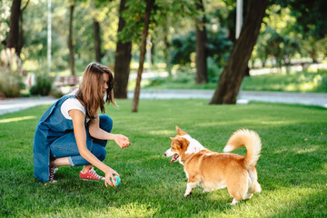 Portrait of woman with dog Welsh Corgi Pembroke in dog park
