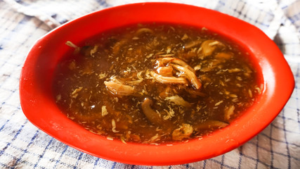 a curry meat soup inside the red bowl