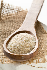 Heap of psyllium husk also called isabgol in wooden spoon on burlap