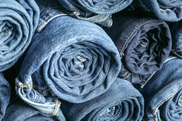 Fototapeta premium Background of a stack rolled jeans, space for text