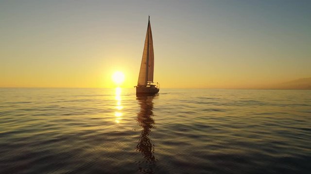 White sailboat floating on a sunset in Spain