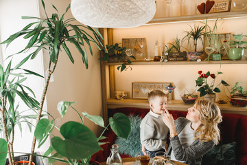 Mom and son with flowers in caffe. Son give flowers to mother. cute family. International women`s day, 8 march celebrating