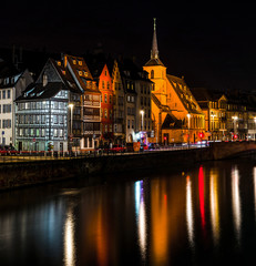 Naklejka premium Saint Nicolas church in Strasbourg night view with reflections in the river Ill