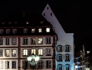 Obraz premium Street lamp and buildings with highlighted windows, night view of Strasbourg