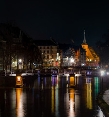 Saint Nicolas church in Strasbourg night view with reflections in the river Ill