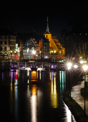 Fototapeta na wymiar Saint Nicolas church in Strasbourg night view with reflections in the river Ill