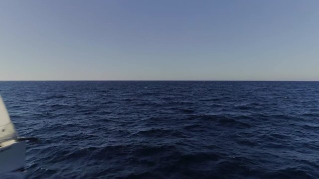 Sailboat butting through the waves in the Mediterranean waters