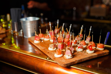 Photo of wooden board with canapes.