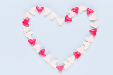 Valentines day background pastel hearts on blue wooden background.