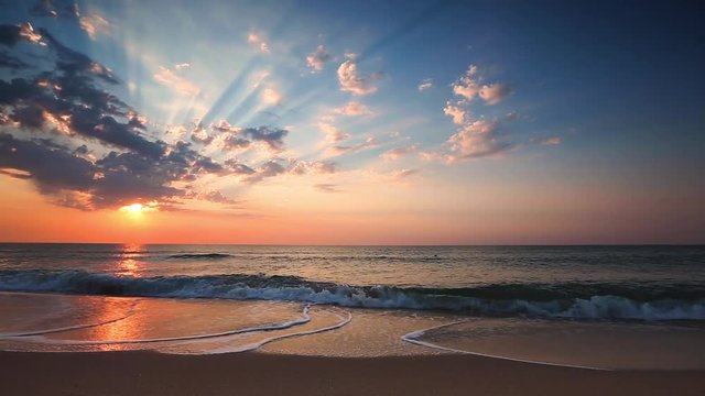sunrise with sky, fluffy clouds, sun rays over the ocean beach, video