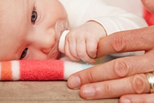 Closeup photo of baby holding father's finger