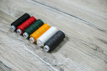 Set of multicolored threads on a wooden background.