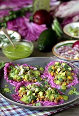 taco keto diet food is wrapped instead of cakes in cabbage leaf of Peking cabbage with avocado mayo, diced avocado, ground beef, onions, corn and cilantro, healthy fats without carbohydrates.
