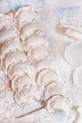 Dumplings in flour on table sprinkled with flour