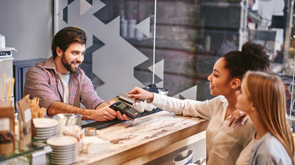 Doing nothing for others is the undoing of ourselves. Small business, payment, people and service concept - woman with credit card buying coffee at cafe or coffee shop