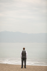 Obraz premium Groom Looking Out to Ocean
