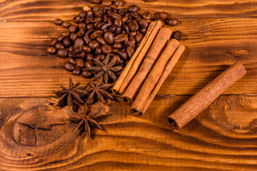 Pile of the coffee beans, star anise and cinnamon sticks on wooden table