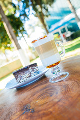 Latte coffee and cake on wooden table at outdoor