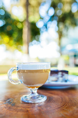 Latte coffee and cake on wooden table at outdoor