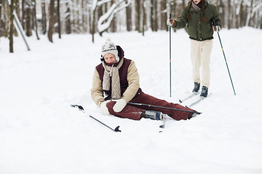 Full Length Portrait Of Hurt Young Man Sitting On Snow Injured During Skiing, Copy Space