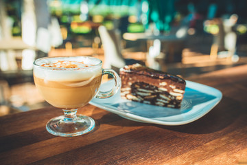 Latte coffee and cake on wooden table at outdoor