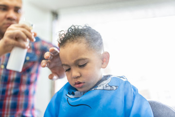 Cute Boy Getting a Hair Cut in a Barber Shop. Beauty Concept.