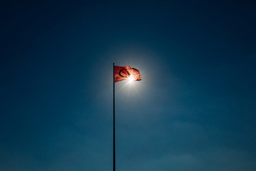 Turkish flag waving at sky with sun. Turkey country flag flowing in the wind in front of sun....