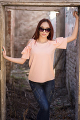 Redheads girl with sunglasses portrait in old retro ruin house with red wall bricks. People rest and lifestyle concept. Close up, selective focus