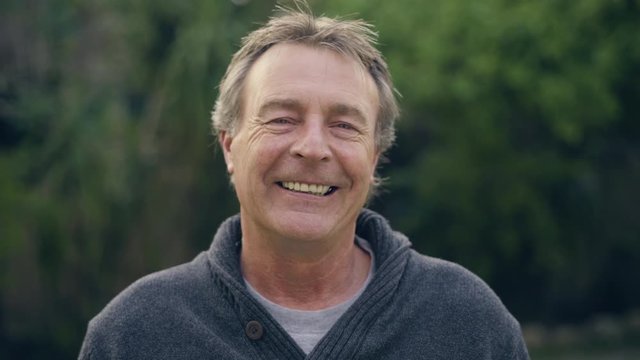 Portrait of a mature adult white male looking into the camera and then smiling