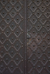 Old forged door with a knob and keyhole