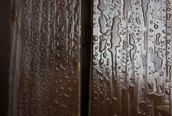 Fragment of wooden bench in the park with water drops