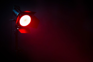 Fototapeta na wymiar Red light with smoke in the dark. Equipment for photo Studio.