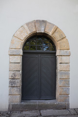 Old arched door on a plaster fasade of building