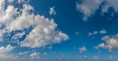 Panorama of peaceful blue sky with puffy white clouds