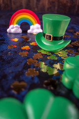 Saint Patrick's Day green leprechaun hat on gold shamrocks reflecting colorful rainbow