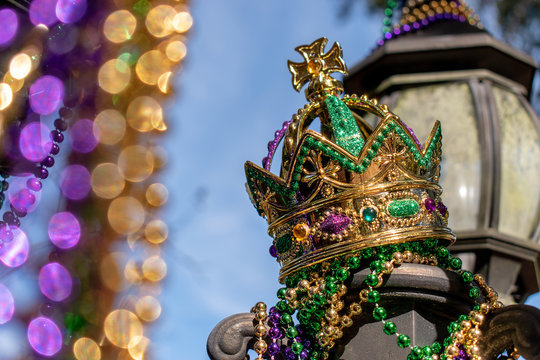 Outdoor Mardi Gras Crown and beads on light post in sunshine