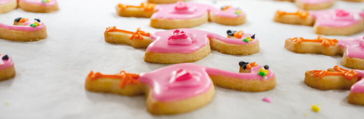 Close up of flamingo frosted sugar cookies on parchment paper.