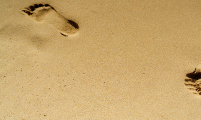 Footprint in sand. Foot imprint in sand on the beach in summer. Sandy beach background. Summer vacation on tropical paradise beach concept. Human footstep stamp in sand. Relax and natural foot spa