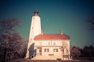 Obraz premium Lighthouse and Keepers Quarters in Sandy Hook, NJ, on a sunny winter day, retro split tone