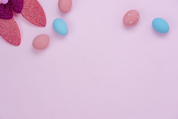 Table top view shot of decorations Happy Easter holiday background concept.Flat lay colorful eggs with cute bunny ear on modern rustic pink paper.Blank space creative design for mock up & template.