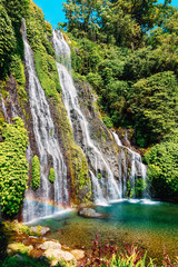 Waterfall with blue crystal water and rainbow in tropical island. Bali, Indonesia