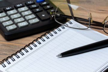 side view calculator notebook and glasses 