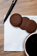 Coffee mug , cookies, pen and white napkin with text space 