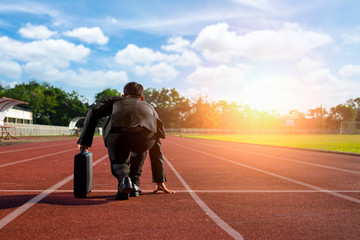 A businessman on a track ready to run