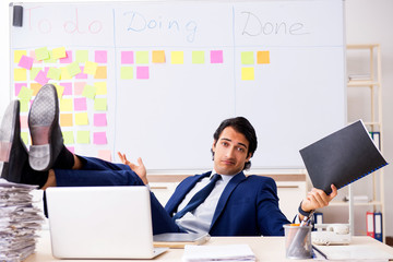 Young handsome employee in front of whiteboard with to-do list  